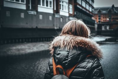 Rear view of woman walking on street in city