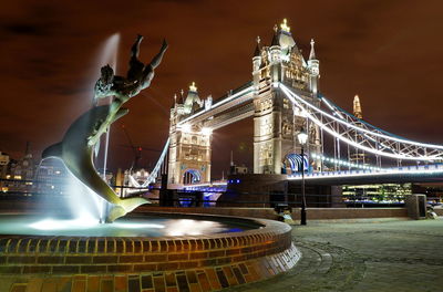 Illuminated statue fountain with tower bridge in background