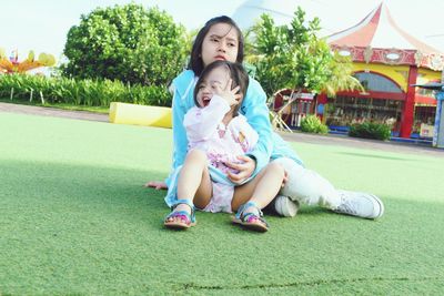 Cute siblings sitting in park