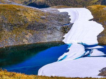 Scenic view of lake by mountains during winter