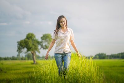 Woman standing on field against sky