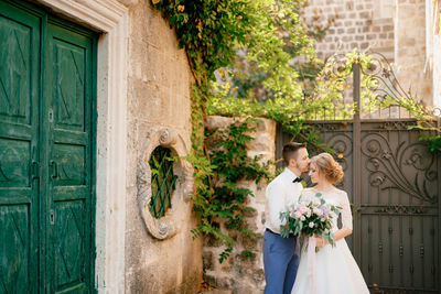 Affectionate couple standing near metal gate