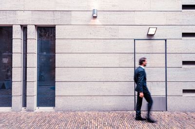 Businessman walking by wall