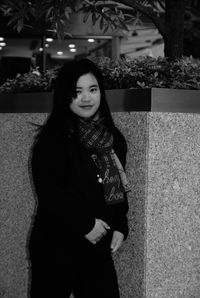 Portrait of smiling woman standing against tree