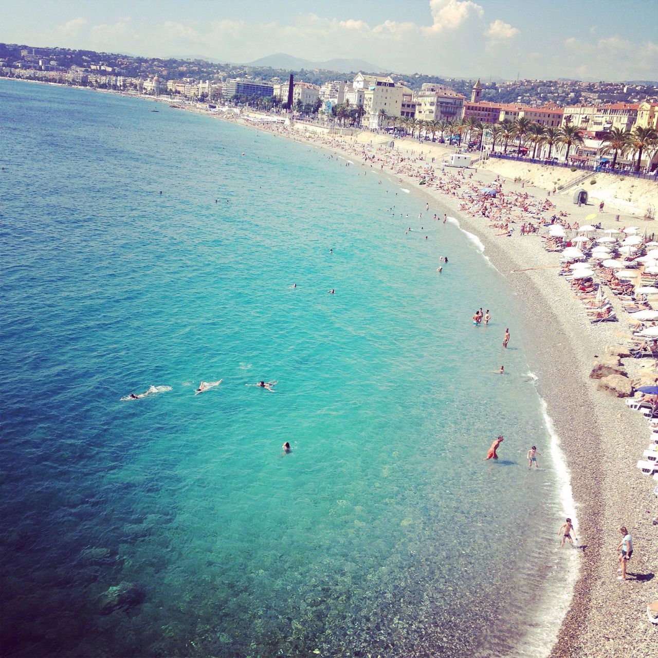 sea, water, beach, high angle view, shore, coastline, sand, vacations, large group of people, city, scenics, horizon over water, nature, incidental people, tourism, travel, travel destinations, building exterior, mixed age range, beauty in nature