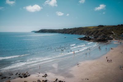 Group of people on beach against sky