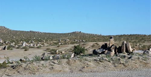 Panoramic view of rocks on field against clear sky