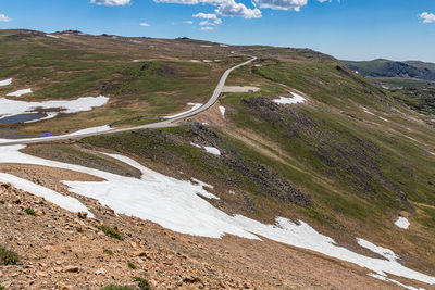 Scenic view of road by mountains against sky