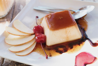 Close-up of creme caramel served with fruits in plate