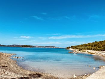 Scenic view of beach against blue sky