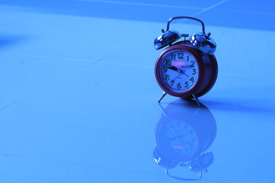 Close-up of clock on tiled floor