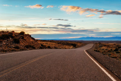 Surface level of road against sky during sunset