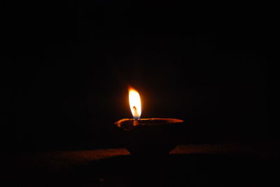 Close-up of burning candle in the dark