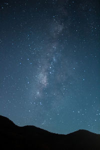 Low angle view of silhouette mountain against sky at night