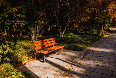 Empty bench against trees on landscape