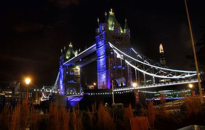 Low angle view of illuminated bridge against sky at night