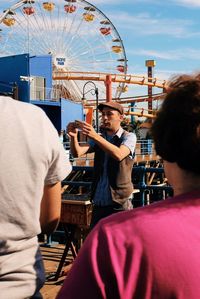 Rear view of man playing guitar at amusement park