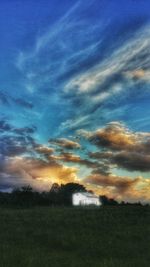 Scenic view of grassy field against cloudy sky