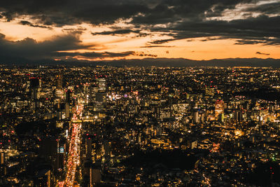 High angle view of illuminated cityscape against sky at night