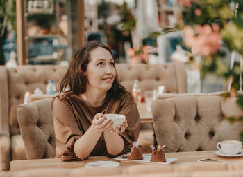 Portrait of smiling woman sitting on table