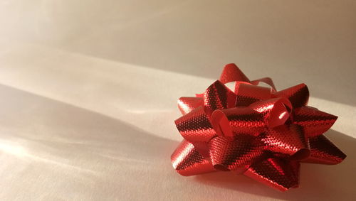 Close-up of red bow on white background
