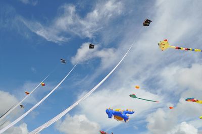 Low angle view of kites flying against sky