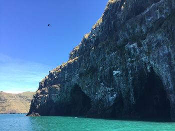 Rock formations by sea against sky