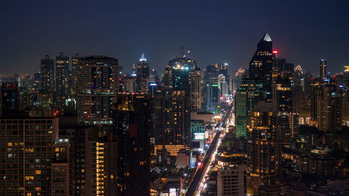 Illuminated buildings in city against sky at night