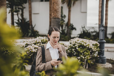 Full length of woman standing against plants