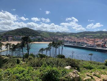 Scenic view of river by buildings against sky