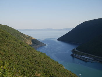 Scenic view of sea and mountains against clear sky