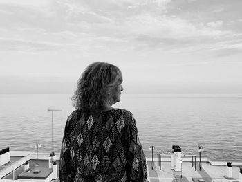 Rear view of woman looking at sea against sky