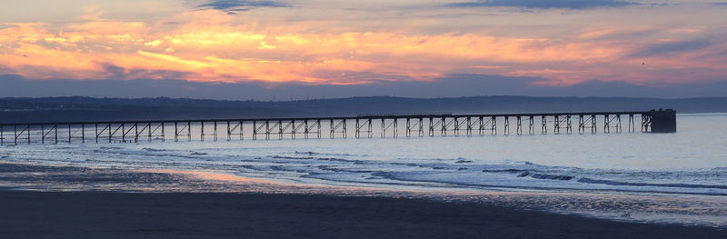 Scenic view of beach against sky during sunset