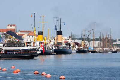 Boats in sea against clear sky