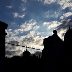 Low angle view of silhouette built structure against sky at sunset