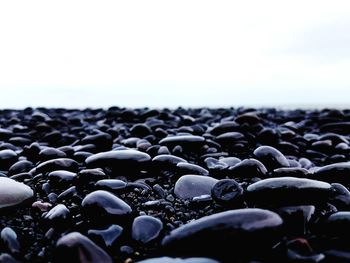 Close-up of stones on beach against sky