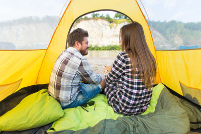 Young couple sitting at tent