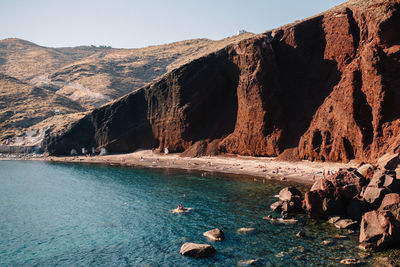 Rock formations by sea against sky