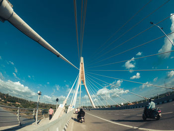 Vehicles on road against sky in city