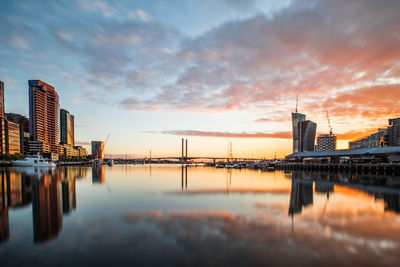 Reflection of city in river during sunset