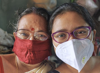 Close-up portrait of mother and daughter wearing protective face mask
