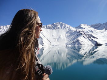 Woman looking at lake and snowcapped mountains