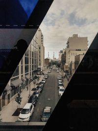 Road amidst buildings in city against sky