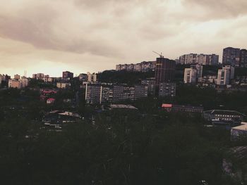 View of cityscape against cloudy sky