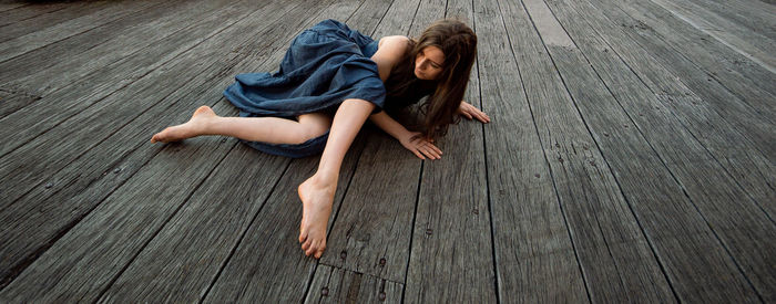 High angle view of woman lying on hardwood floor