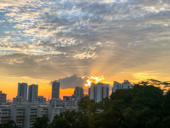 Buildings in city against sky during sunset