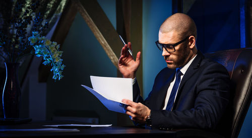 Businessman reading documents at desk in office