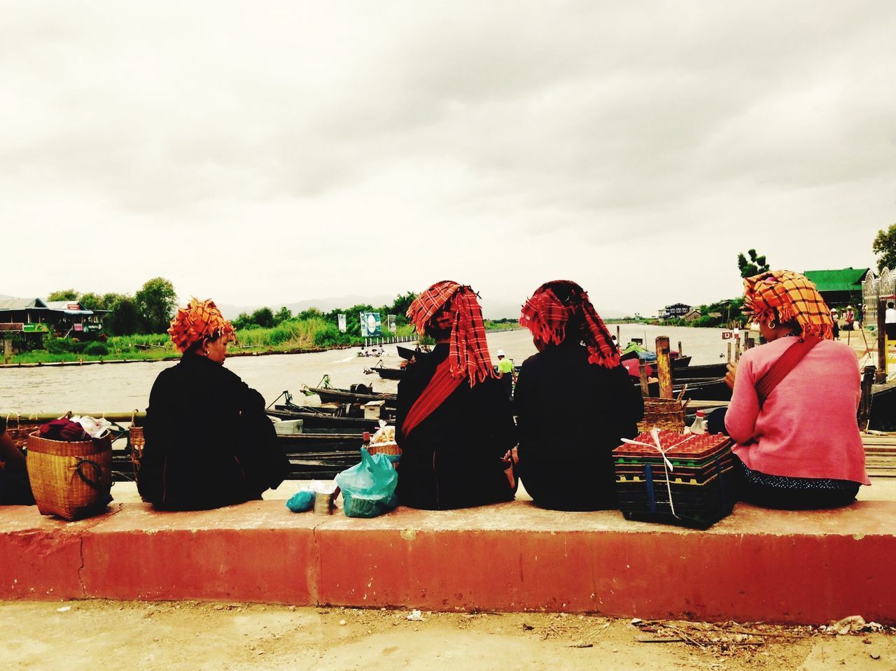 REAR VIEW OF PEOPLE LOOKING AT MARKET STALL