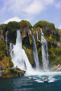 Duden waterfall in antalya turkey. mediterranean sea. small boat with people on the waves