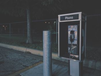 Telephone booth on footpath at night